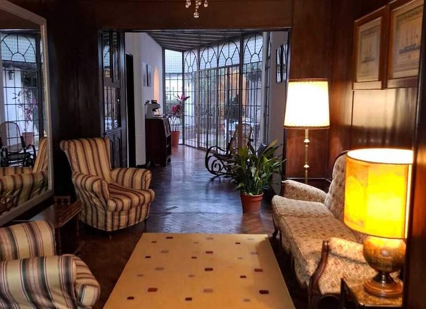 La Teresita Hotel Boutique in Salta lobby with striped chairs, lamps, and a glass doorway to the patio