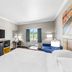 Days Inn by Wyndham Rockdale Texas guest room with king bed, TV, chair, desk and window view