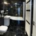 Residence U Cerne Veze bathroom with black marble tiles, sink, toilet, and bathtub in České Budějovice
