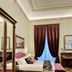 Palazzo Monga Boutique Guesthouse Verona bedroom with pink velvet bed and tall curtains