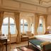 Taj Fateh Prakash Palace Udaipur room with lake views, arched windows, and a king bed in Udaipur.