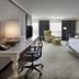Hilton Garden Inn Montreal Airport guest room with king bed, desk, chair, lounge chair and ottoman in Montreal