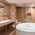 Aimoer Hotel Foshan bathroom with round soaking tub, glass shower, and vanity