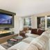 Antlers at Vail living room with fireplace, wall-mounted TV, and mountain-view windows in Vail