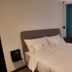 Vila Lili in Rovinj guest room with bed, wall-mounted TV, desk and teal curtains