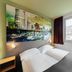 B&B Hotel Düsseldorf City-Süd guest room with twin bed and cityscape wall art in Düsseldorf