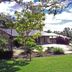 Emeraldene Inn & Eco-Lodge in Hervey Bay, garden courtyard with bungalow-style rooms and outdoor seating