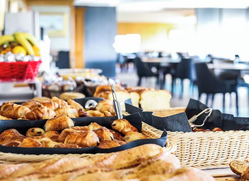 Breakfast buffet at La Confiance in Le Mont-Saint-Michel with baskets of pastries and bread