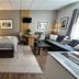 The Churchill Court, Woodstock guest room with king bed, sofa, table, and TV