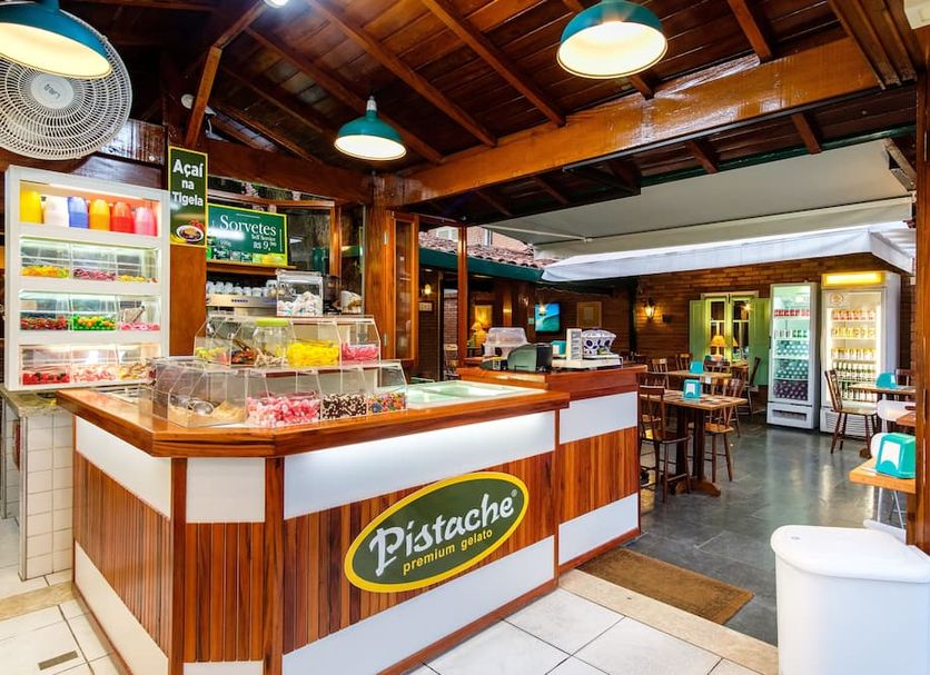 Pousada Don Diego in Ubatuba, a colorful sorveti counter and seating area with wood ceiling