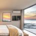 Sovn Experience+Lifestyle in Cape Town bedroom with ocean-view balcony, sunset and wall-mounted TV