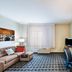 TownePlace Suites by Marriott Tulsa North/Owasso guest suite with sofa, desk, TV and window view in Owasso