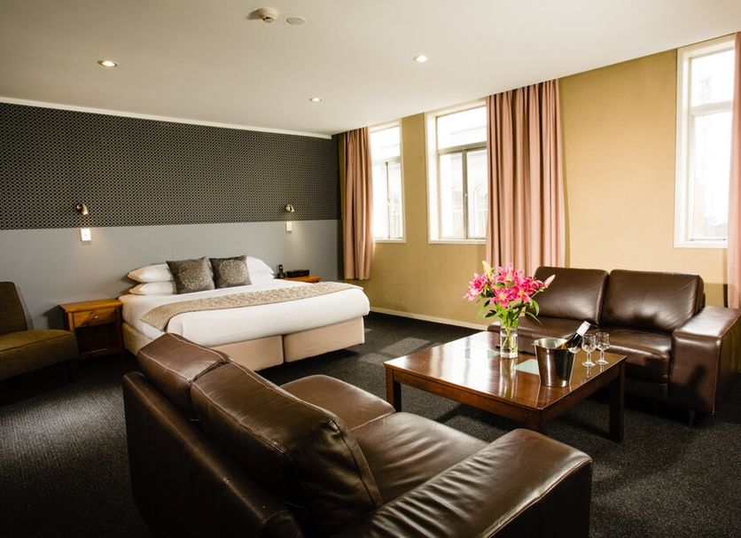 The Grosvenor in Timaru guest room with king bed, leather seating, coffee table and windows