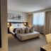 Hotel Los Españoles Plus Santiago guest room with sofa, bed, desk and large windows
