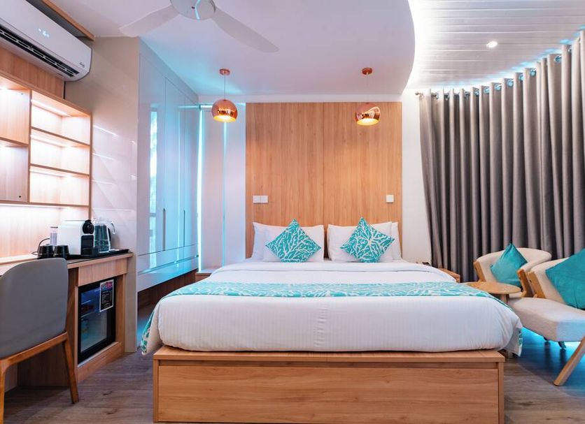 Hotel Star Shell in Malé guest room with king bed, desk, lounge chair and soft blue accent lighting