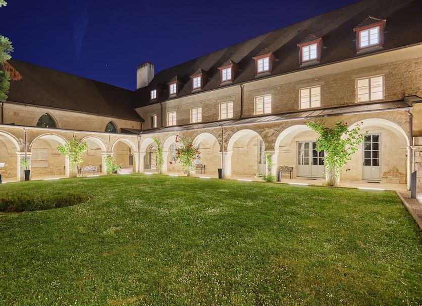 Appart'hôtel Odalys City - Dijon Centre Les Cordeliers courtyard with arched colonnade and lawn at night