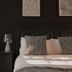 Domaine Jolivent in Lac Brome, bedroom with dark walls, framed art, and a bed with gray pillows