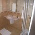 Cirali Almira Bungalow bathroom with beige tile, pedestal sink, shower enclosure and towel racks