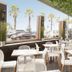 Hotel Bondi, Sydney outdoor terrace with tables, chairs, palm trees and oceanfront view