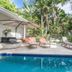 Cove Studios in Byron Bay with a tropical poolside patio, loungers, and lush palm trees
