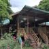 Kinabalu Poring Vacation Lodge in Kundasang with wooden lodge entrance, stairs, and lush garden