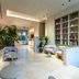 Una Hotels Villa Dei Platani Foligno lobby with lounge seating, plants and built-in shelving