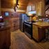 A Cabin In The Woods in Pigeon Forge kitchen with wood paneling, stainless fridge and dining table