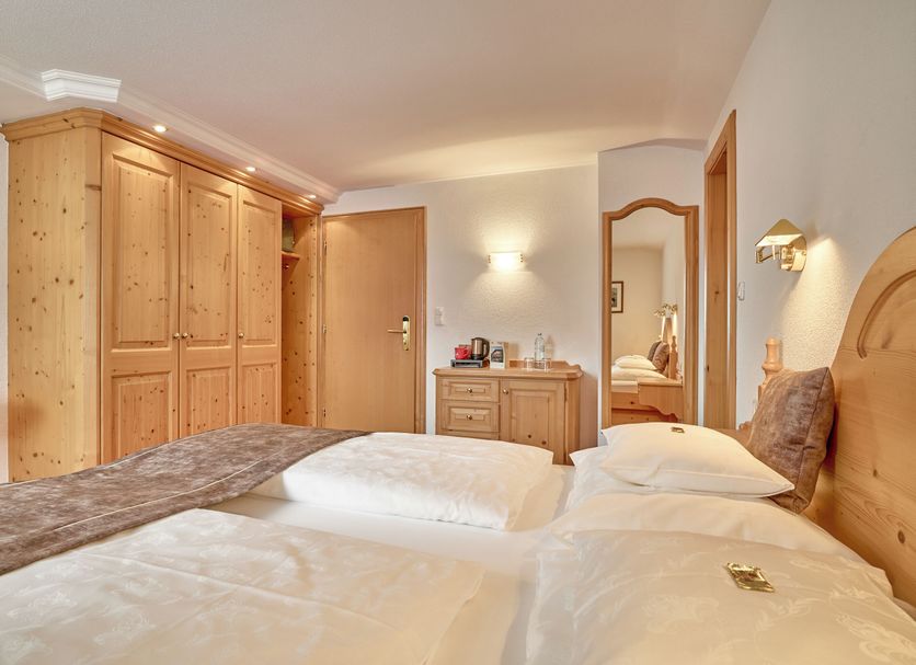 Hotel Appartement Roggal in Lech am Arlberg guest room with twin beds, wooden wardrobe and dresser