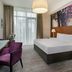 Moyvalley Hotel & Golf Resort guest room with king bed, desk, purple chairs and large window