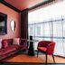 Naumi Hotel Wellington lounge with red velvet sofa, accent chair and floor-to-ceiling windows in Wellington