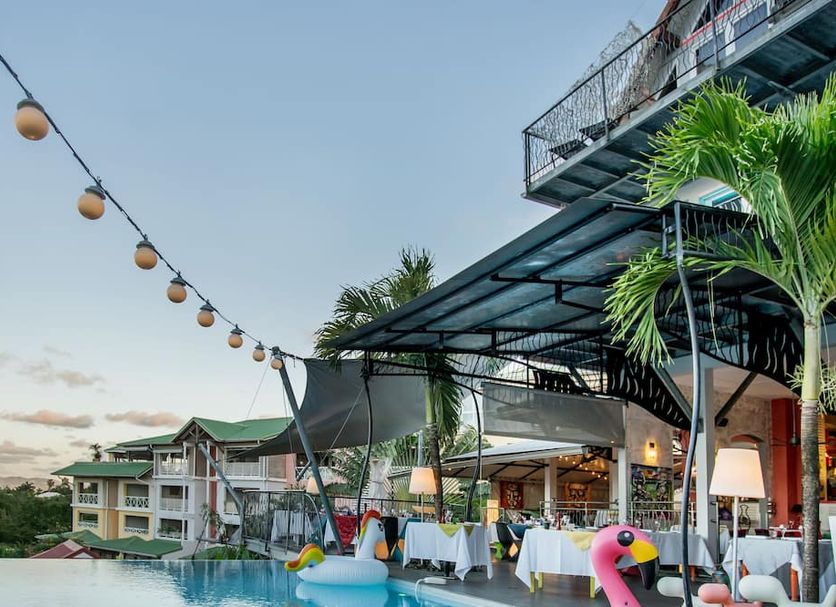 La Suite Villa in Les Trois-Îlets with outdoor dining terrace, string lights, and poolside palm views