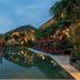 Sahaja Sawah Resort, Tabanan: tropical resort pool at dusk with lounge chairs and palm trees
