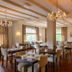 Hotel Bemelmans in Schin op Geul dining room with chandeliers, tables, chairs and large windows