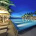 Naman Retreat Da Nang infinity pool with ocean view at dusk and palm trees