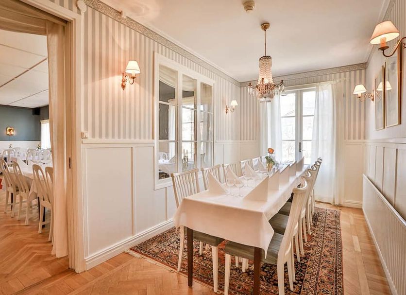 Järvsöbaden in Järvsö dining room with long set table, chandeliers and striped walls