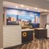 La Quinta Inn & Suites by Wyndham Fort Worth City View lobby check-in desk with city skyline wall mural