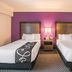 La Quinta Inn & Suites by Wyndham Fort Worth City View room with two double beds and purple accent wall