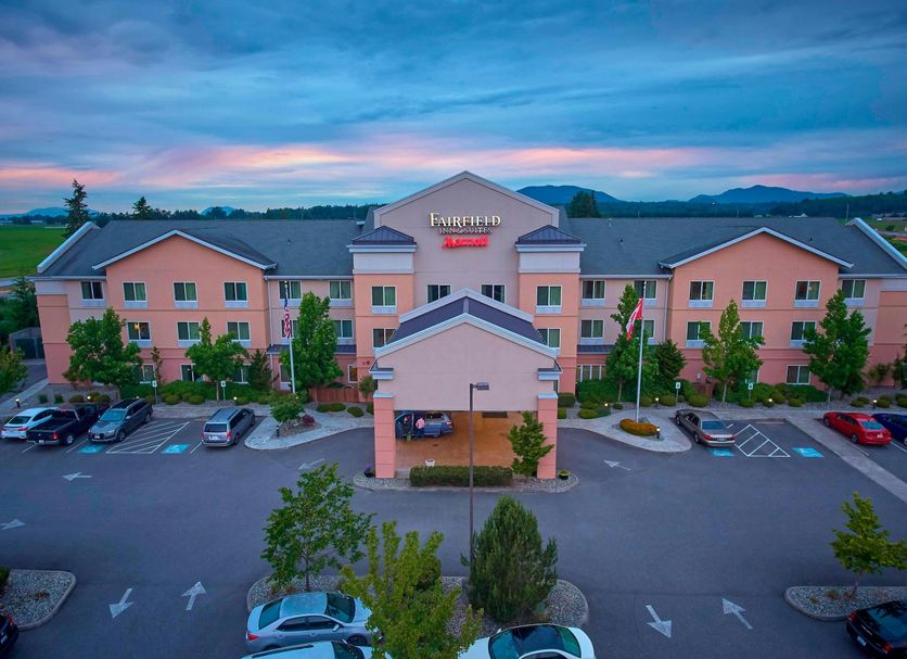 Fairfield Inn & Suites by Marriott Burlington exterior at dusk with parking lot and mountain backdrop