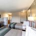 HomeTowne Studios by Red Roof Austin room with two beds, TV, desk and kitchenette