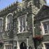 The Bedford Hotel in Tavistock, historic stone facade with tall arched windows and hanging flower baskets