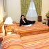 Hotel Diego de Almagro Puerto Montt room with two striped beds, TV, desk and seated guest