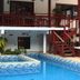 Vila Atlantica Inn in Camburi with a small outdoor pool and red wooden stairs beside the patio