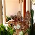 Misty Green Homestay Thekkady veranda with wicker chairs, potted plants and a small table