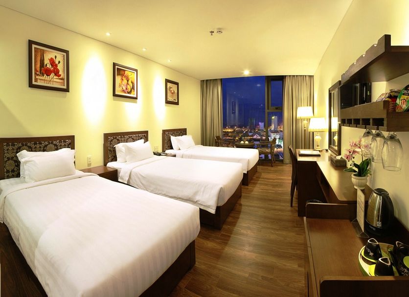 Danaciti Hotel Da Nang guest room with three twin beds and city-view window