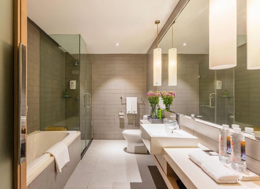 Ziction Liberal Hotel Xi'an bathroom with soaking tub, glass shower, double vanity and toilet