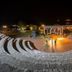 Akay Garden Family Club in Ildir: outdoor amphitheater-style terrace lit at night near the water