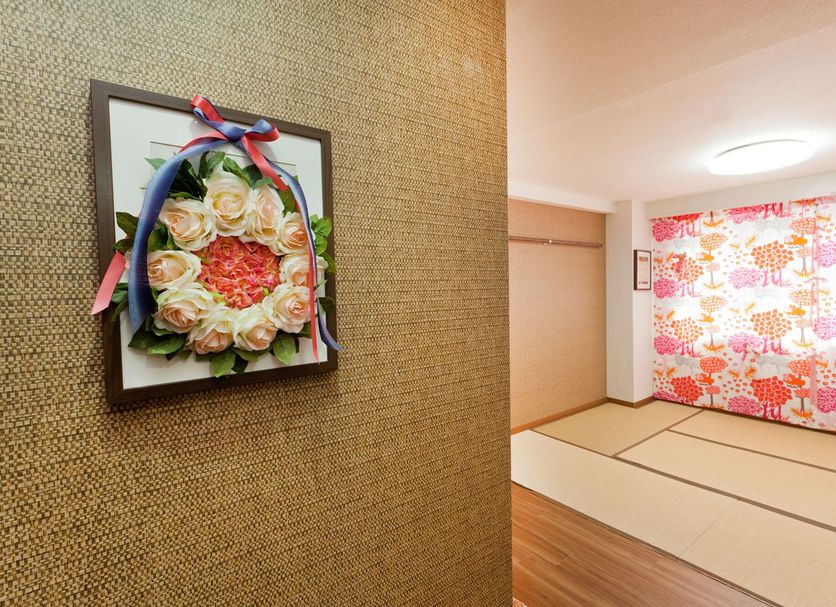 Hanabi Hotel Tokyo hallway with framed floral wall art and tatami-style room with colorful accent wall