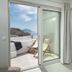 Arkasa Palace in Arkása, balcony with sea view and lounge chairs beside a bedroom