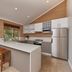 Eight Willows Retreat Metricup kitchen with island, stools, stainless steel appliances and garden view