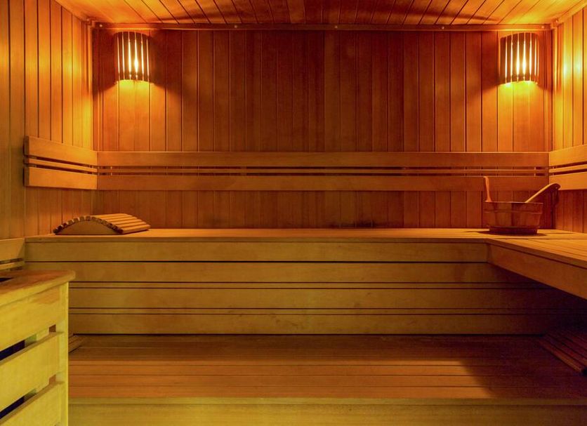 Relax Hôtel Beuzeville Honfleur sauna interior with wooden benches and warm lighting in Honfleur